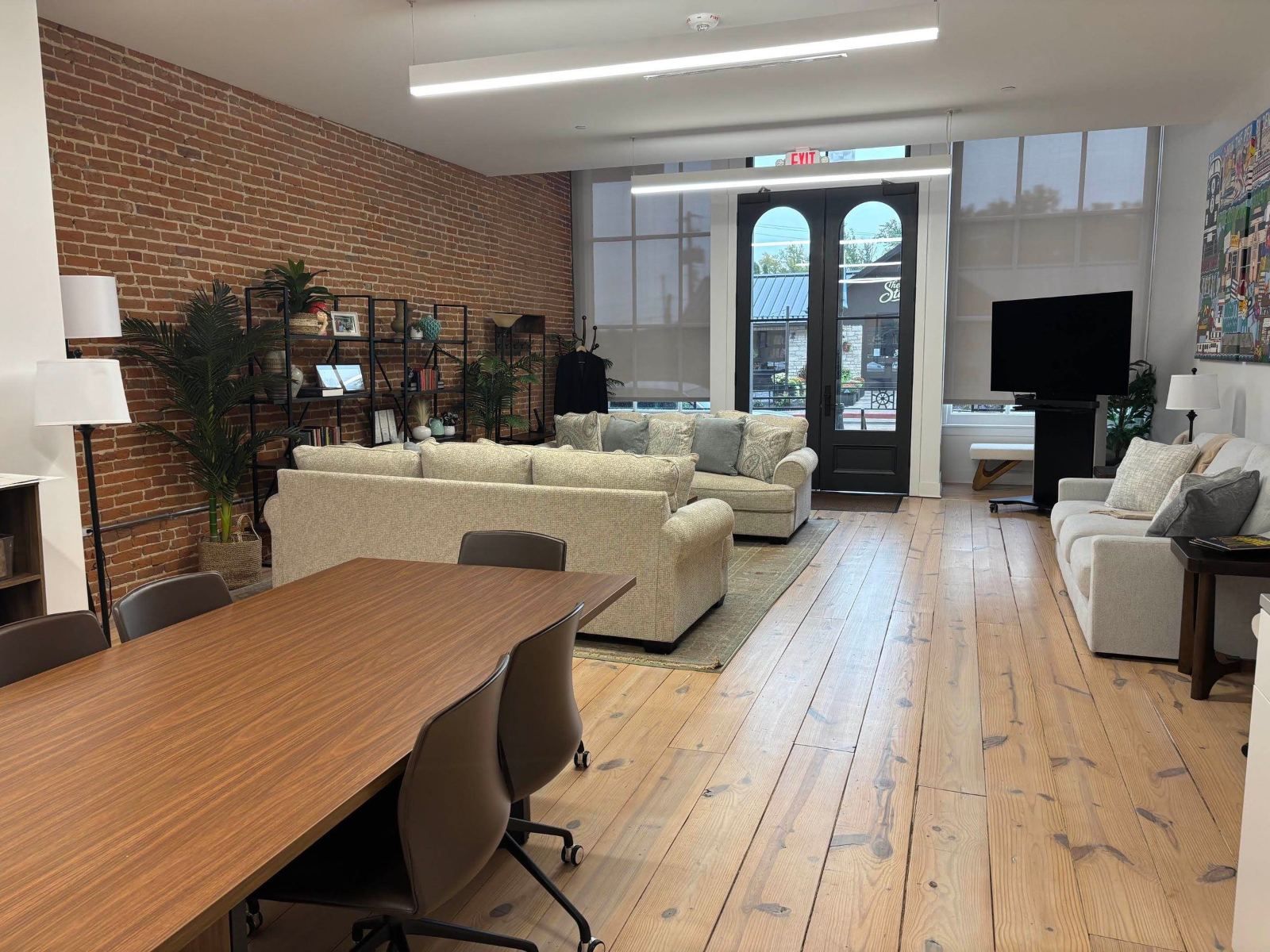 Suite 101 with exposed brick wall, wood floors, and arched front doors to Main Street